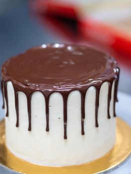 unrecognizable worker preparing a sweet dripping choco cake and berries
