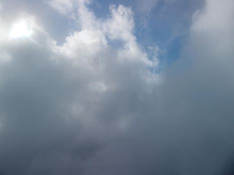 Aerial view drone flying above white clouds dense fog move quickly. Drone flies high back in blue sky through fluffy clouds. Beautiful foggy and cloudy slow moving Aerial view. Fog sea.