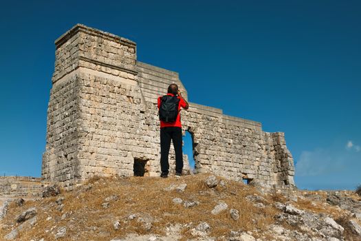 man with camera photographing the Roman ruins of acinipo in Ronda, Malaga