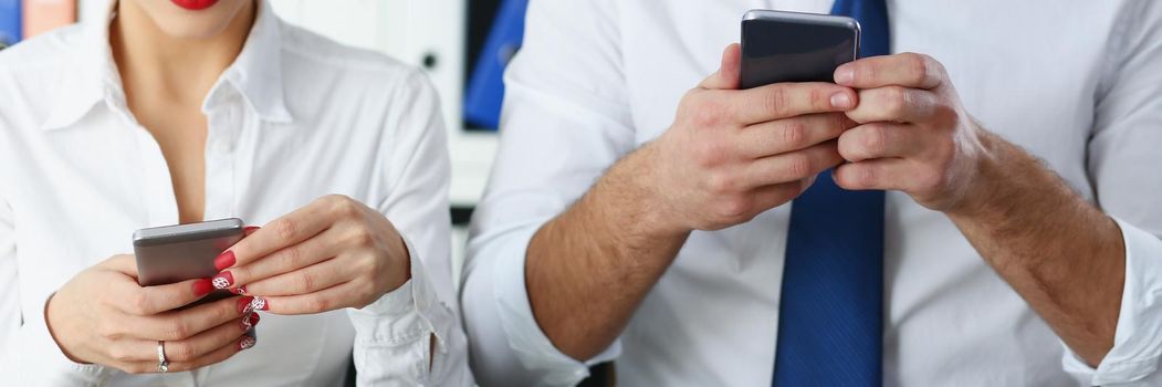 Portrait of group of people hold devices and look at phone screen in office. Read news, mania, send messages non stop, chat addict. Mobile addict concept