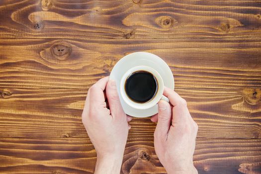 Cups with a coffee in the hands of men and women.