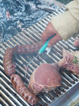 cooking pork meat in the grill outdoors with charcoal
