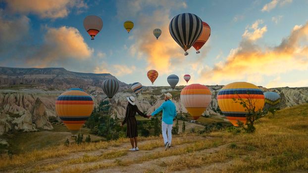 Kapadokya Cappadocia Turkey, a happy young couple during sunrise watching the hot air balloons of Kapadokya Cappadocia Turkey during vacation