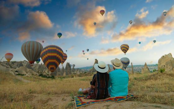 Kapadokya Cappadocia Turkey, a happy young couple during sunrise watching the hot air balloons of Kapadokya Cappadocia Turkey during vacation