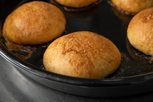 Freshly baked hot burger buns in an industrial oven