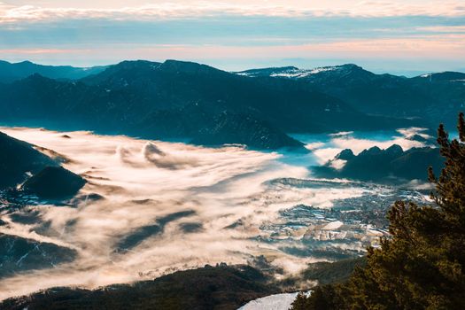 Beautiful view of a valley in a winter morning, with fog covering trees and houses. In the morning the cold weather is make floating fog on the mountain as a sea of mist