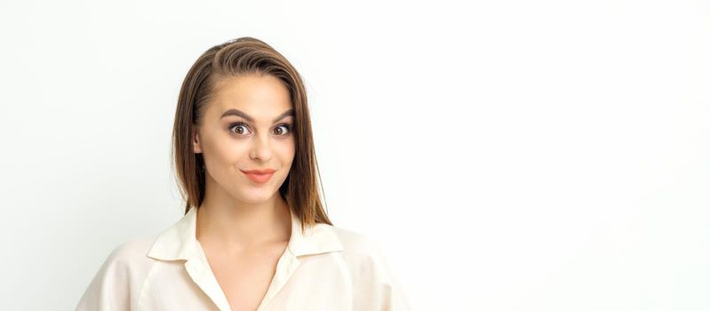 Portrait of a beautiful young caucasian smiling brunette woman with long straight hair standing and looking at the camera on white background