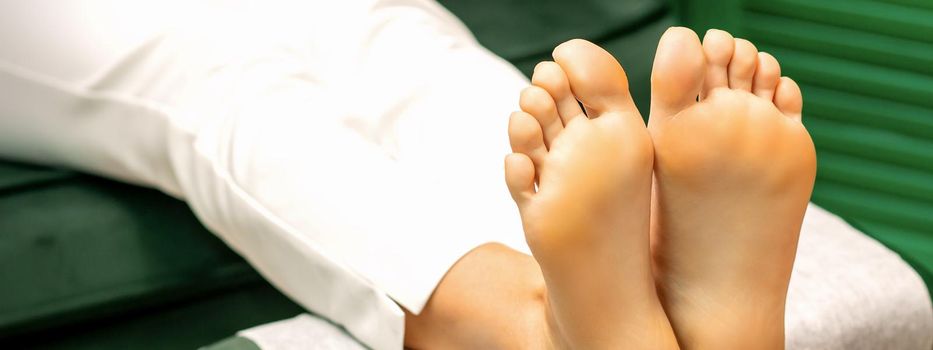 Feet of a young caucasian woman while treatment procedure in a beauty salon