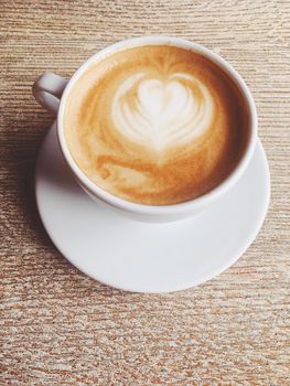 Morning drink, breakfast and rustic style concept - Cup of hot cappuccino in a cafeteria, coffee on a wooden table in cafe