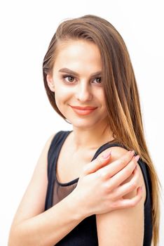 Portrait of a beautiful young caucasian smiling brunette woman with long straight hair standing and looking at the camera on white background