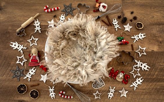 Newborn baby studio furniture basket for Christmas infant child photoshoot with fur and Xmas toys and wooden decoration. Tiny designed scene bed for kid New Year holiday studio portrait