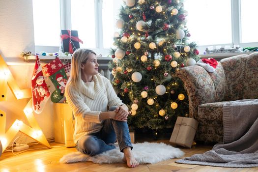 young beautiful woman near christmas tree.