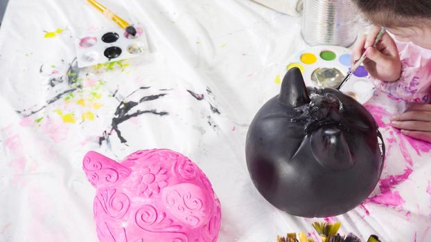 Painting craft pumpkin with acrylic paint for Halloween.