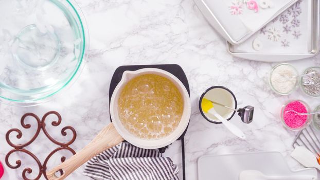 Flat lay. Step by step. Caramelizing sugar in a small cooking pot over the small electric stove.