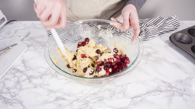 Step by step. Mixing ingredients in a mixing bowl to bake cranberry muffins.