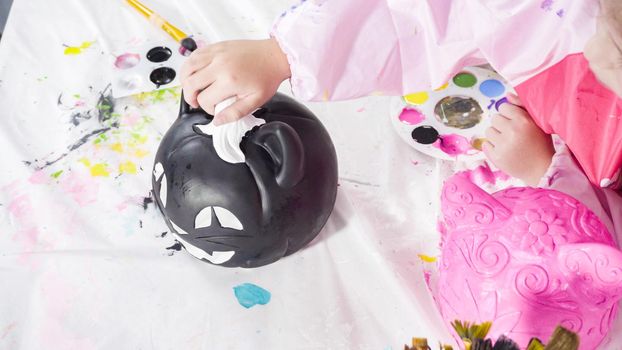 Painting craft pumpkin with acrylic paint for Halloween.