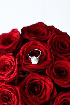 Gemstone jewellery, wedding present and engagement proposal concept - Beautiful white gold pearl ring and bouquet of red roses, luxury jewelry love gift on Valentines Day and romantic holidays