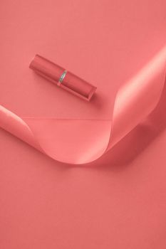 Cosmetic branding, glamour lip gloss and shopping sale concept - Luxury lipstick and silk ribbon on coral holiday background, make-up and cosmetics flatlay for beauty brand product design