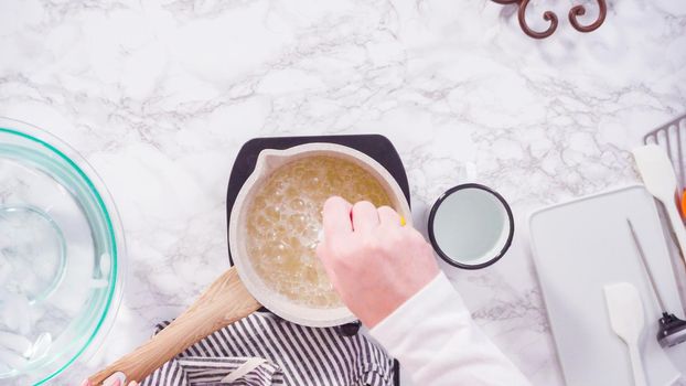 Flat lay. Step by step. Caramelizing sugar in a small cooking pot over the small electric stove.