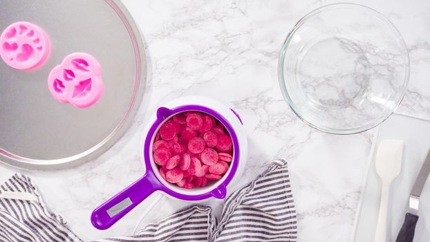 Flat lay. Step by step. Melting red chocolate chips for chocolate molded shapes.