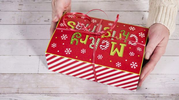 Step by step. Packaging homemade fudge and cookies into a Christmas gift box.