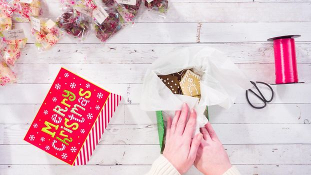 Flat lay. Step by step. Packaging homemade fudge and cookies into a Christmas gift box.