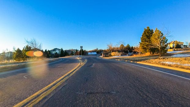 Driving on typical paved roads in a suburban upscale residential neighborhood of America.
