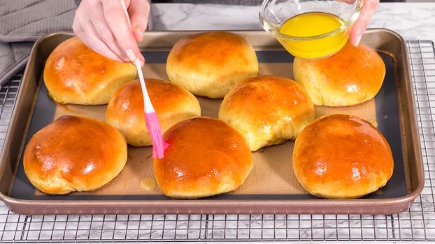Step by step. Freshly baked brioche buns on a baking sheet with a silicone mat.