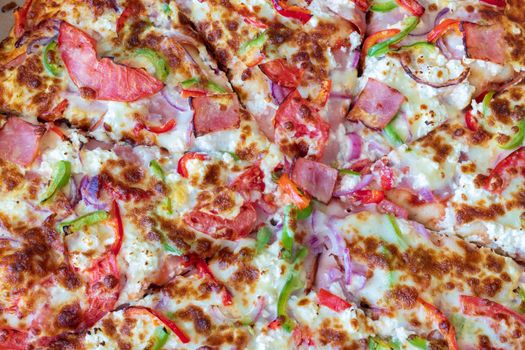 Fresh pizza with tomatoes, ham, onion and cheese. Tasty takeaway food. 