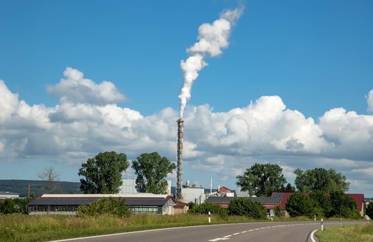 Small factory with chimney near road.