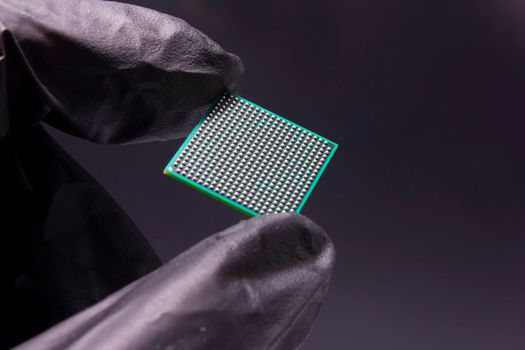 Semiconductor BGA chip in a hand on a black background