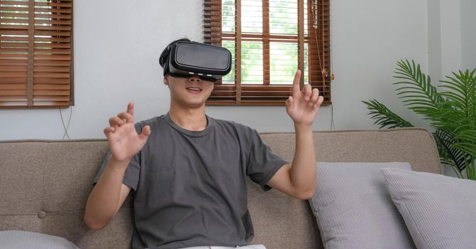 young asian man touching the air during the VR experience.