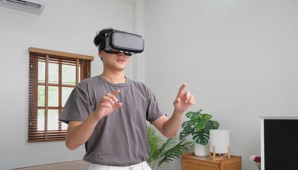 young asian man touching the air during the VR experience.