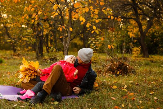 Young handsome father holding his little daughter in a sunny autumn forest. Father's day. Father's love