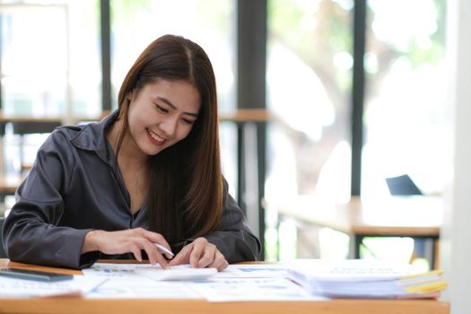 businesswoman hands using a calculator to check company finances and earnings and budget. Business woman calculating monthly expenses, managing budget