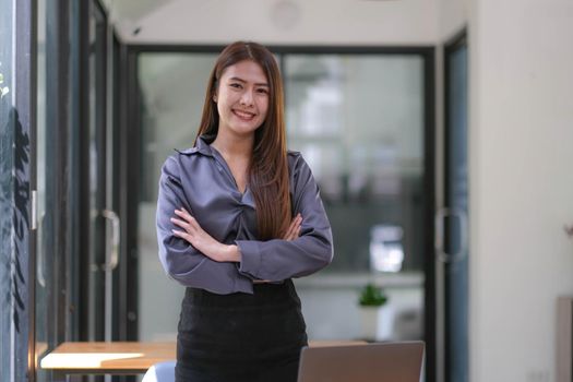 Confident Asian businesswoman standing with her arms crossed. smiling and looking at the camera..