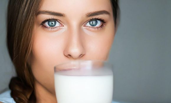 Diet and wellness, young woman drinking milk or protein shake cocktail, portrait