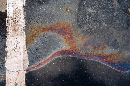 Gasoline stains on asphalt. Gasoline spilled on road.