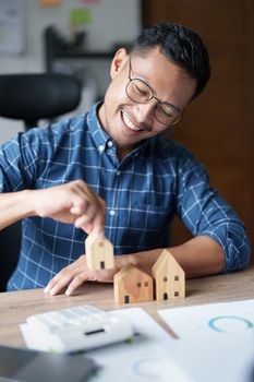 Entrepreneurs, business owners, accountants, real estate agents, A young man using a calculator to calculate his home budget to assess the risks of investing in real estate.