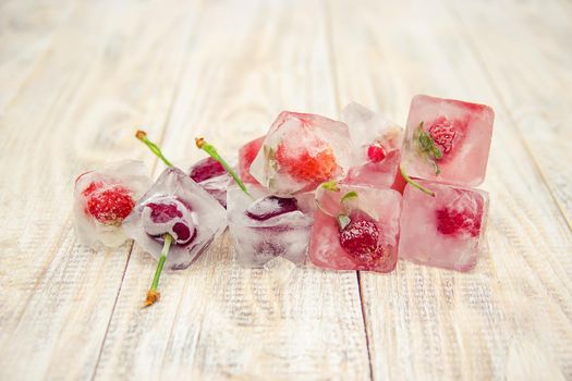 Berries frozen in ice cubes. Selective focus.