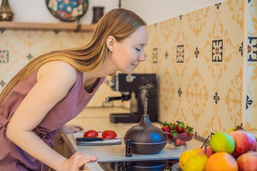 Woman prepares food next to an aroma diffuser. cook cuts ripe red peppers in the kitchen. Cooking fresh, ripe, bell pepper salad for guests. Summer fresh vegetable salad.