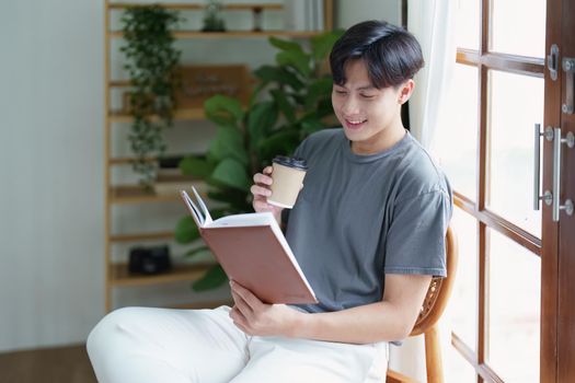 Portrait of an Asian teenager using a digital tablet on the sofa while relaxing at home.