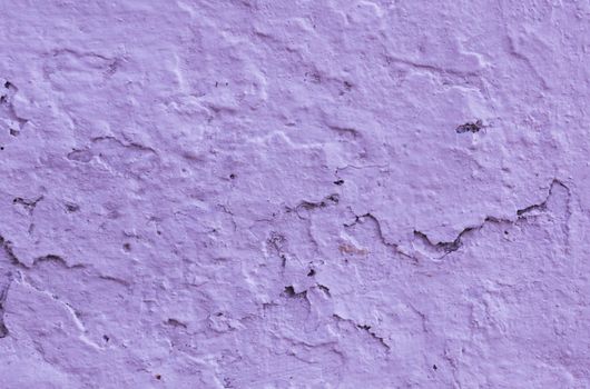 Damaged old plaster on wall in lilac color. Texture for design with copy space.