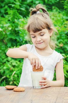 The child drinks milk and cookies. Selective focus.