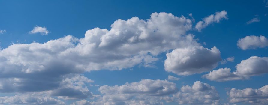 Cumulus clouds against the blue sky on a summer day. Widescreen