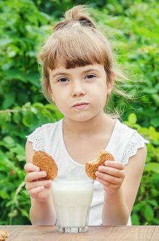 The child drinks milk and cookies. Selective focus.