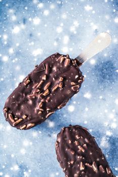 Christmas time, sweet dessert and festive menu concept - Chocolate almond ice cream on marble table with glowing snow, winter holiday food background
