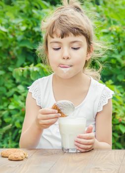 The child drinks milk and cookies. Selective focus.