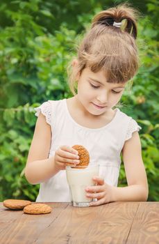 The child drinks milk and cookies. Selective focus.