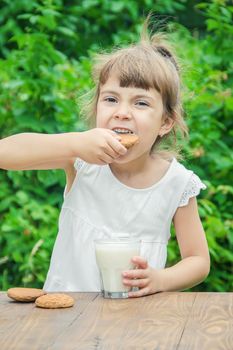 The child drinks milk and cookies. Selective focus.